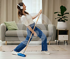 Woman, singer and broom to clean living room with funny dance, sweeping floor and rock performance in home. Girl, comic