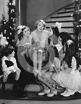 Woman singing with children on staircase at Christmas