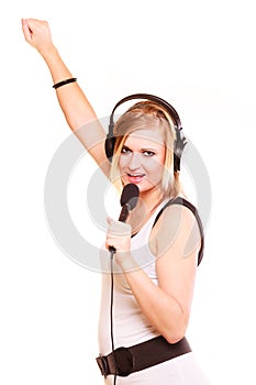 Woman singing to microphone wearing headphones