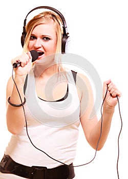 Woman singing to microphone wearing headphones