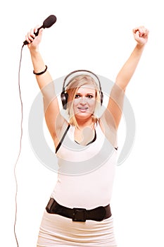 Woman singing to microphone wearing headphones