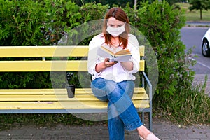 Woman in singular mask read book in the park