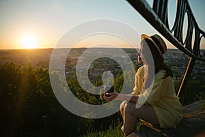 Woman sit on the hill and lookin on sunset