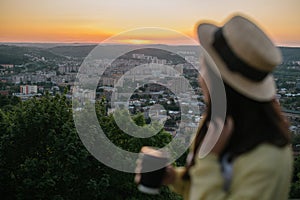 Woman sit on the hill and lookin on sunset