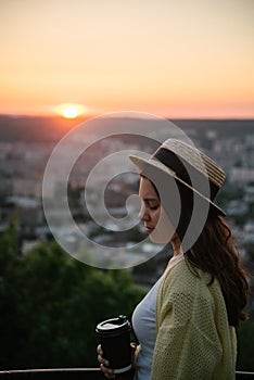 Woman sit on the hill and lookin on sunset