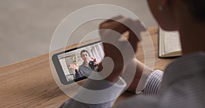 Woman sit indoor holding smartphone participating in videocall with friend