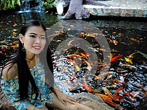 Woman sit beside koi fish pool