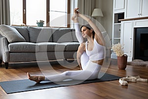 Woman sit on mat perform Compass or Sundial yoga asana