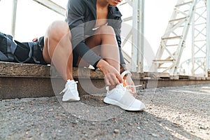 Woman sit outdoors tie laces on shoes