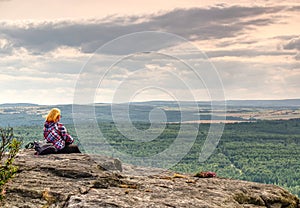 Woman sit silhouette in mountains, sunset and fall landscape. Female hiker looking over edge at beautiful Sunset