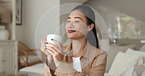 Woman sit on sofa drinking tea or coffee with pleasure