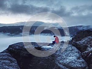 Woman sit on summit in hands holding flash bolb. Girl waiting