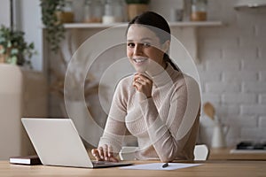 Woman sit at table with laptop smile look at camera