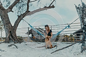 Woman siting in the hammock with dog