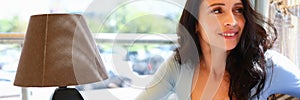 Woman sits in cafe with friend and holds smartphones in her hand