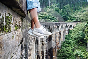 Woman sits on the Demodara nine arches bridge in Ella, Sri Lanka photo