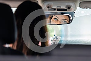 Woman sits on driver seat and Looks in the rear view mirror