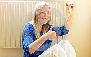 Woman sits in front of radiators photo