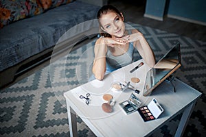 Woman sits before mirror. Woman making make-up