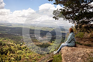 Woman sits on a mountain cliff