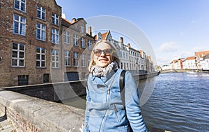 Woman sits near water on Jan van Eyck Square in Bruges, Belgium