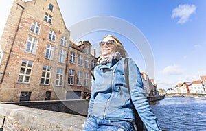 Woman sits near water on Jan van Eyck Square in Bruges, Belgium