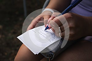 A woman sits and notes on the receipt what has been bought on her wallet