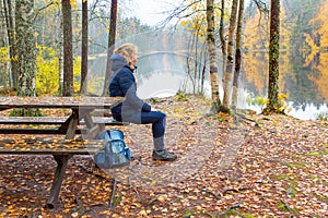 Woman sits at picnic table in finnish nature