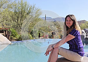 A Woman Sits Poolside in Arizona`s Sonoran Desert