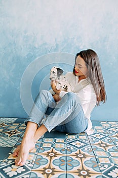 Woman sits with puppy of dalmatian dog