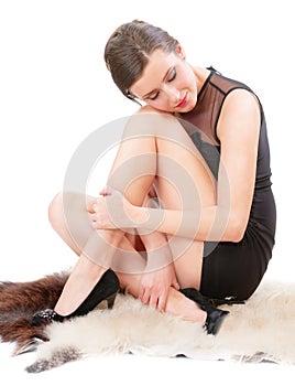 Woman sits on soft fluffy sheep skin