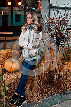 A woman sits on straw with pumpkins. Ingathering. Halloween Celebration