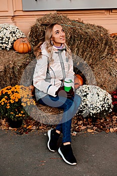 A woman sits on straw with pumpkins. Ingathering. Halloween Celebration