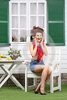 Woman sits at white wooden table with fruits and flowers