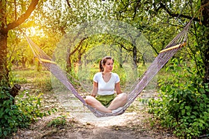 Woman sittin in hammok in the green garden