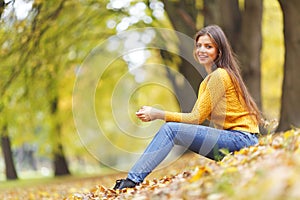 Woman sitting on autumn leaves