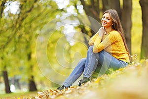 Woman sitting on autumn leaves