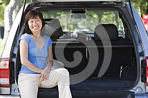 Woman sitting in back of van smiling
