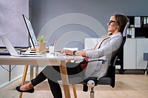 Woman Sitting In Bad Posture Working On Computer