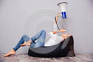 Woman sitting on bag chair and shouting in megaphone