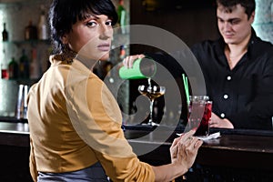 Woman sitting at a bar waiting to be served