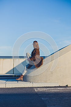 Woman sitting on barrier in the road