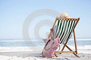 Woman sitting on beach in deck chair