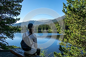 woman sitting at bear lake in spring summer in the rocky mountain national park, colorado united states of america