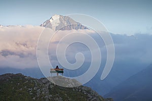 Woman Sitting on Bench and Looking at Mountain View