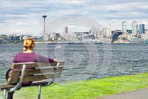 Woman Sitting on Bench Looking At The Seattle, Washington Skyline