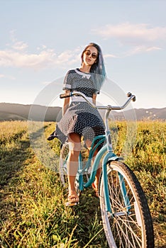 Woman sitting on a bicycle cruiser on countryside path.