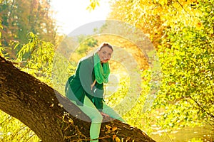 Woman sitting on big tree trunk