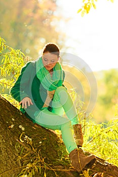 Woman sitting on big tree trunk