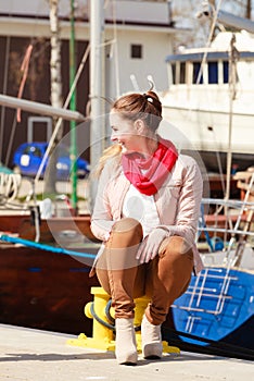 Woman sitting on bitt in marina